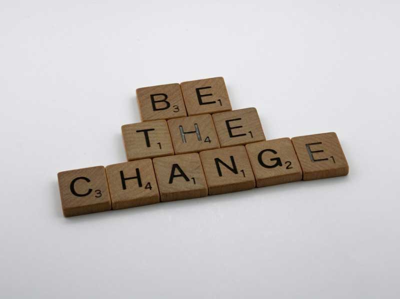 Scrabble pieces spelling out "be the change". 