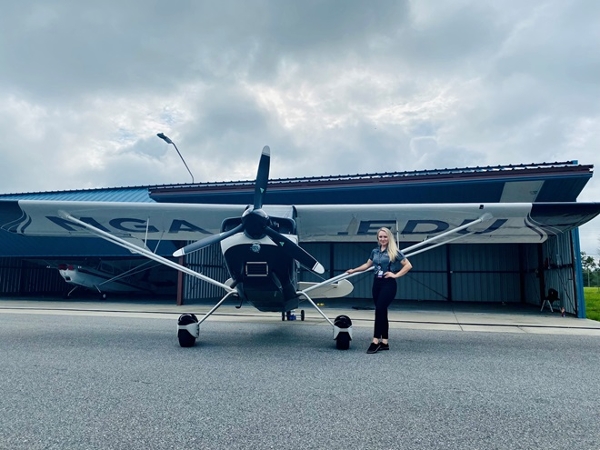 Angela Rogers, an aviation student at Middle Georgia State University, is pictured with her university’s Super Decathlon--an airplane she hopes to fly in aerobatic competitions. Photo courtesy of Angela Rogers.