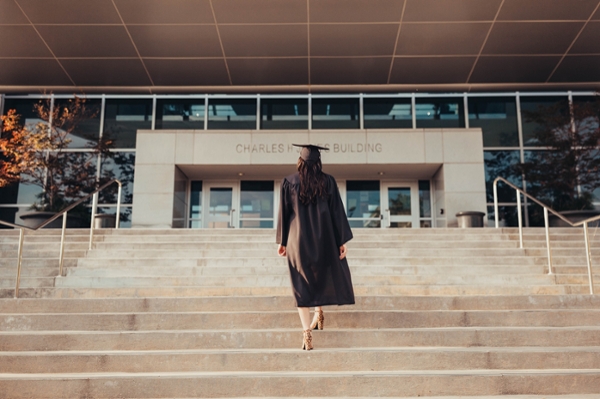 Graduate walking up the stairs of the MGA Jones Building.