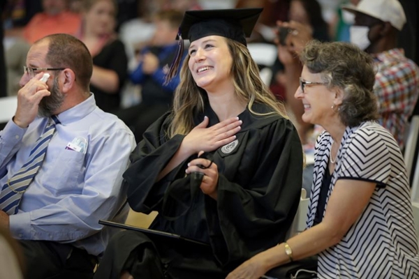 Student and her family sharing an emotional moment, crying, at graduation.