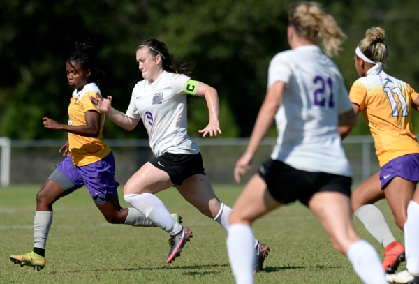 Knights women's soccer player running during a game.