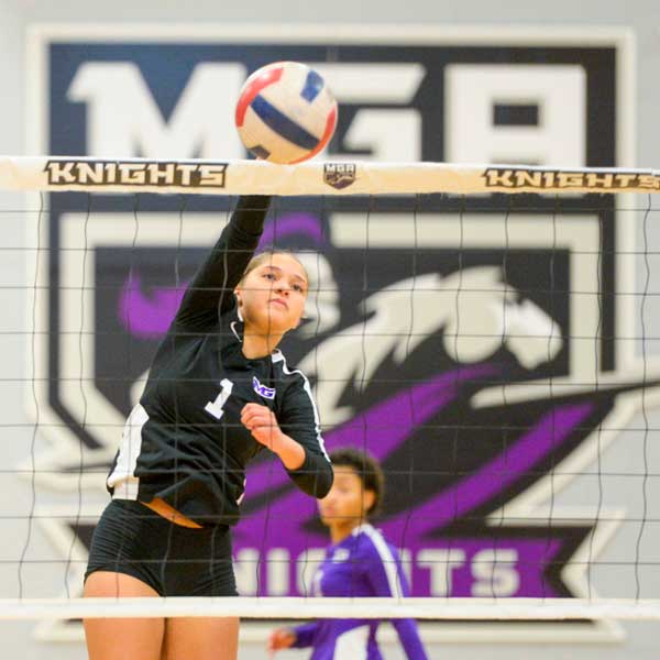 Knights volleyball player spiking the ball during a game. 