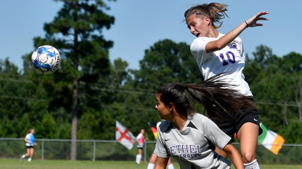 Knight's women's soccer player head butting the ball during a game.