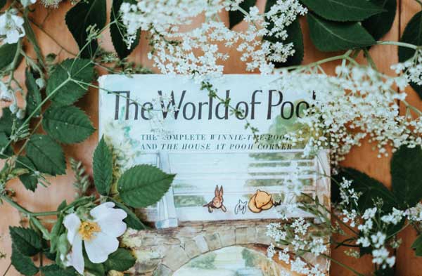 Flatlay of a WInnie the Pooh book covered with baby's breath. 
