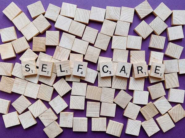 Scrabble letters on a flat lay that spells out "self care."