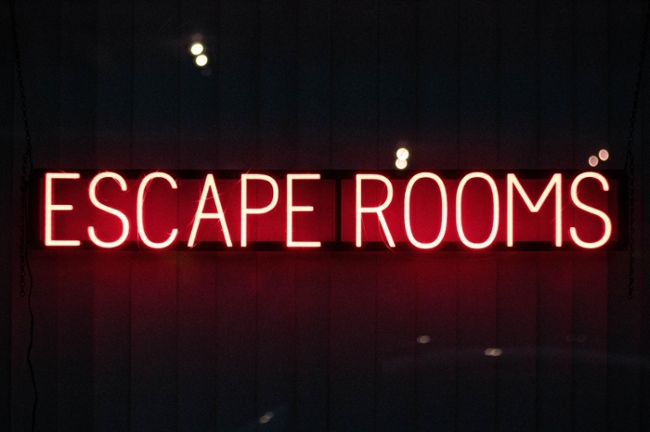 Red neon sign that reads "escape rooms." 