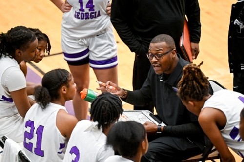 Knights women's basketball team huddles during a game with their coach.