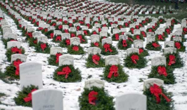 Wreaths sitting on gravestones. 