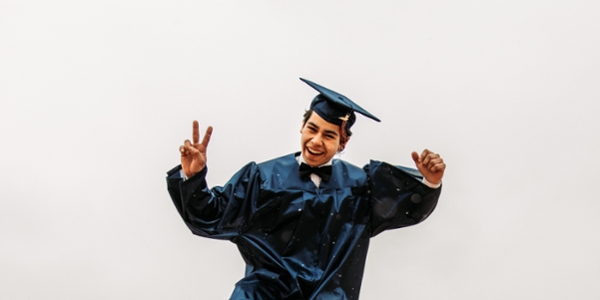Male graduate poses in his cap and gown.