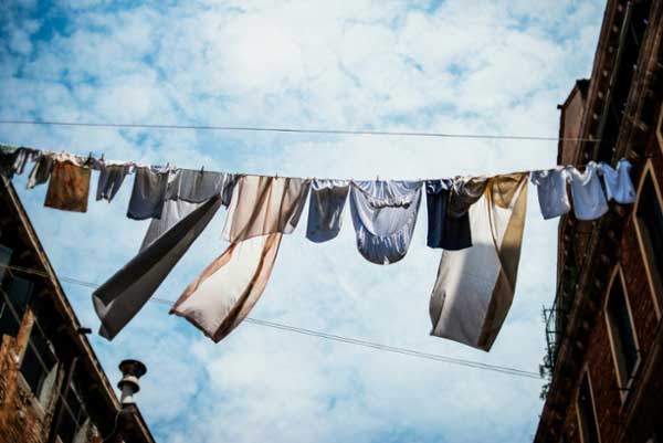 Clothesline with drying clothes hanging from it against a blue sky. 