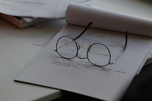Glasses sitting on a notepad. 