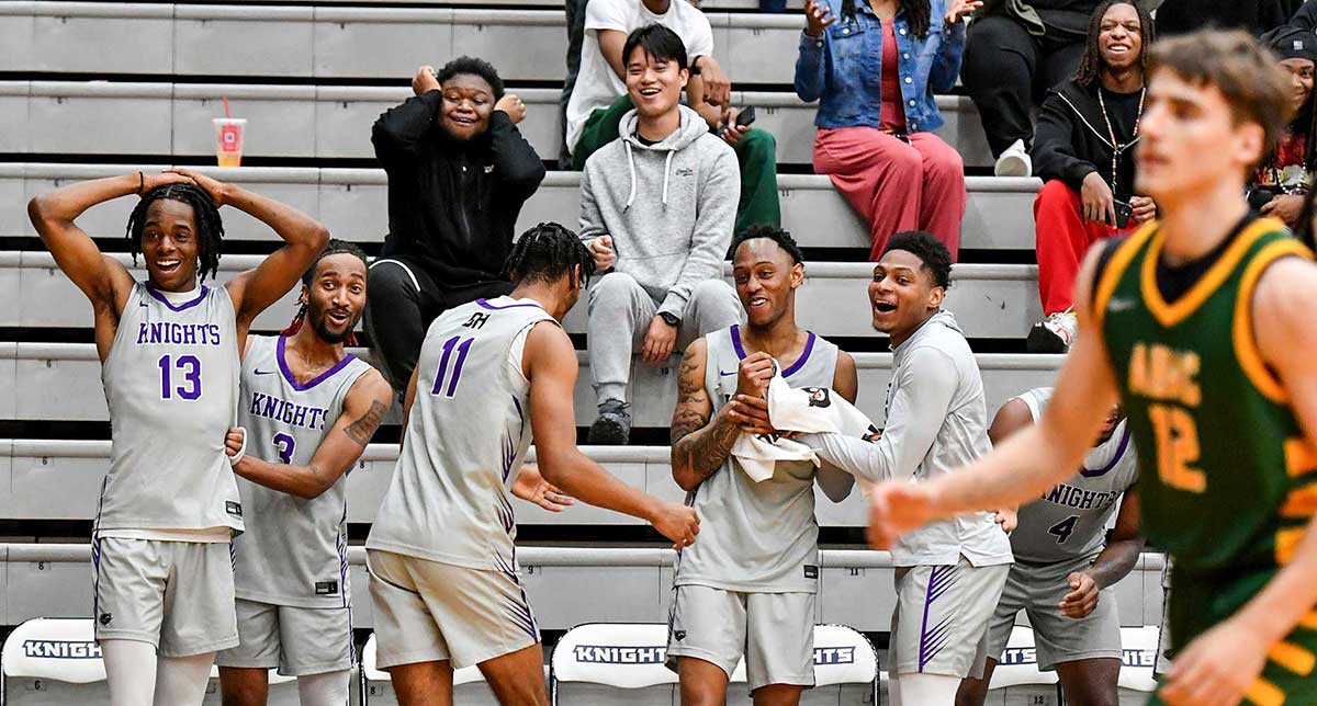 Knights men's basketball celebrates a win on the sidelines. 