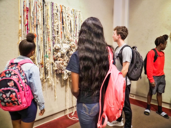 Students look at artwork displayed in MGA's Peacock Gallery.