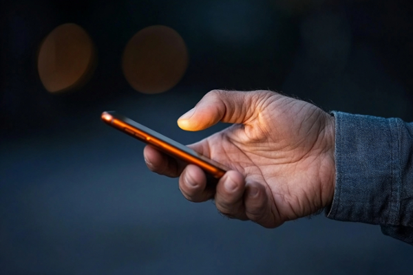 Hand holding a cell phone, scrolling. 
