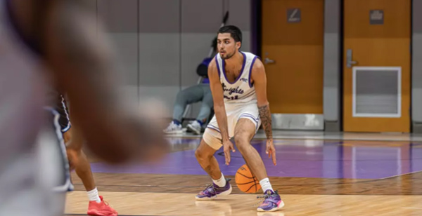 Knights men's basketball player dribbles the ball on the Morris Gym court during a game against Tigers of Vorhees University.