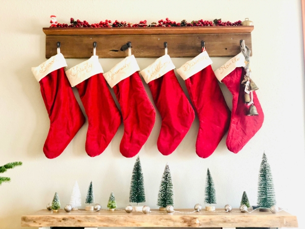 Red Christmas stockings hang from a mantle. 
