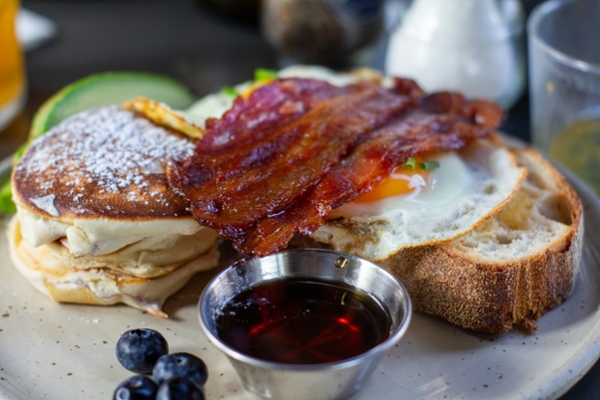 Breakfast platter of French toast and bacon with berries.