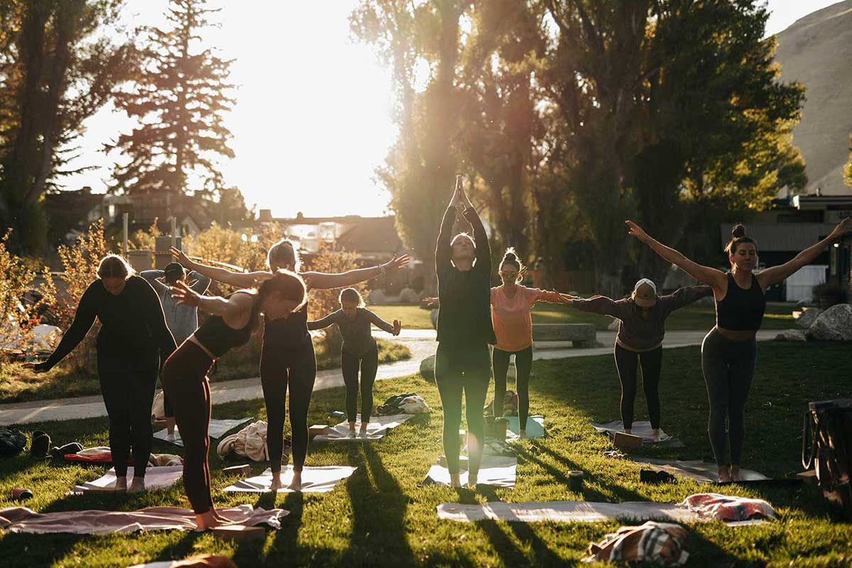 People doing yoga in a park. 