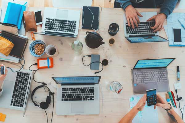 Various electronics (laptops, headphones, etc.) and snacks sitting on a table.