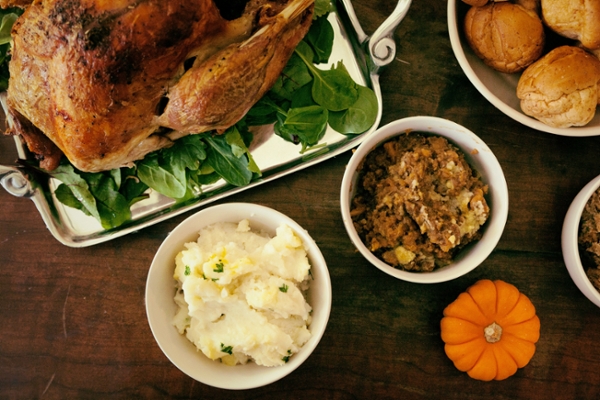 Thanksgiving meal of mashed potatoes, turnkey, and stuffing displayed on a table.