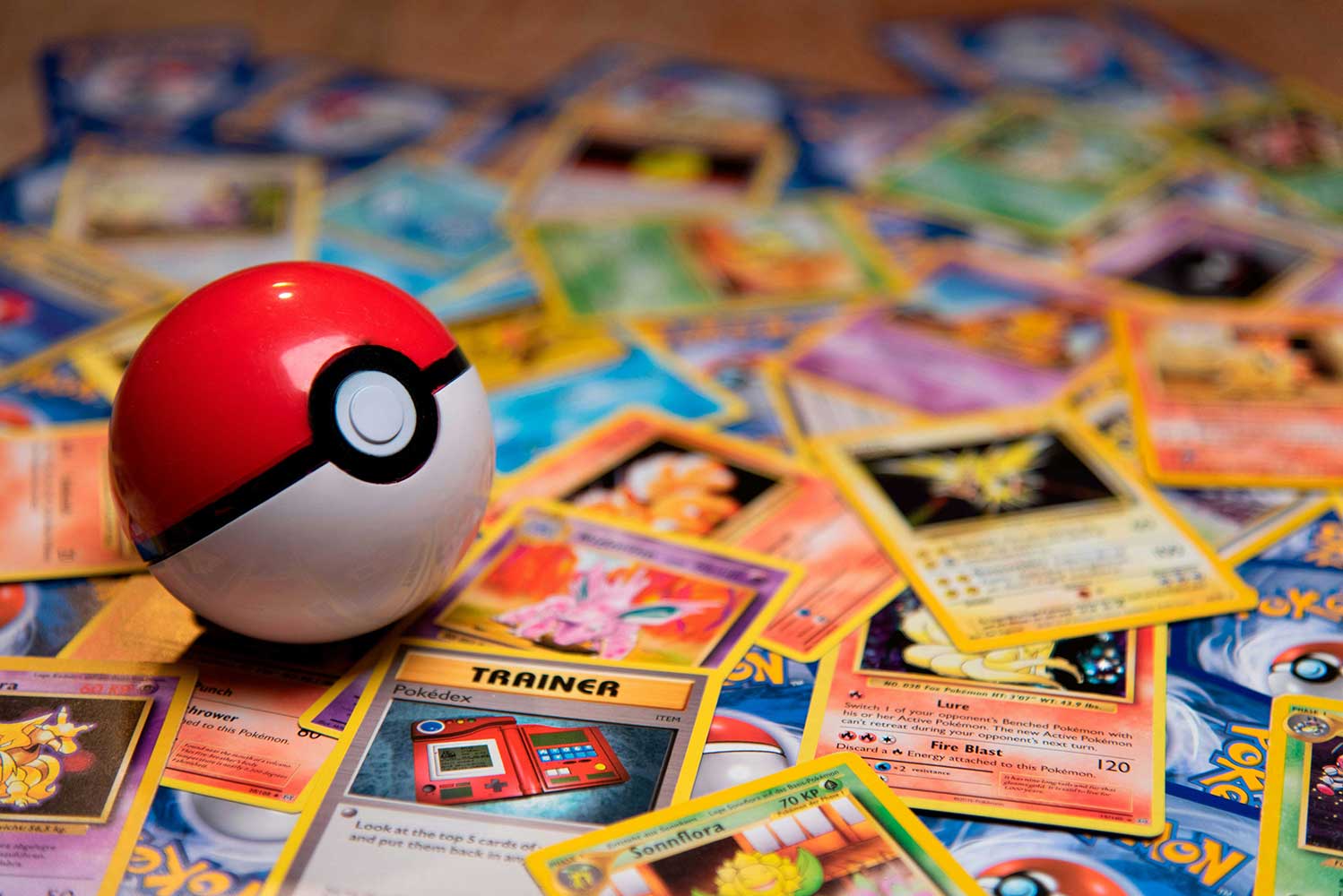 Pokemon ball sits on Pokemon cards.