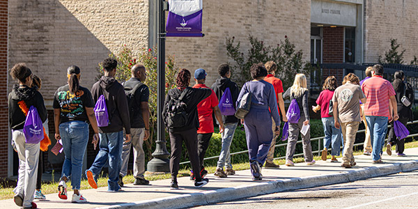 Students and their families walking outdoors during a campus tour of MGA's Cochran campus.