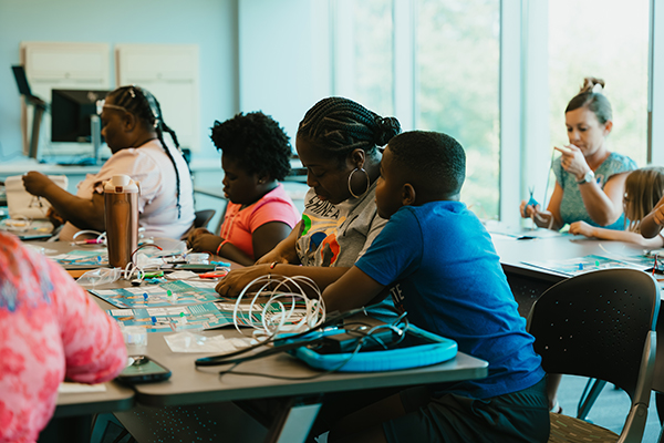 Participants and their children build electrical circuits