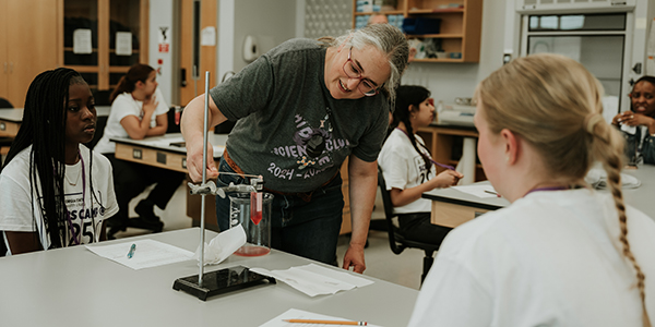 Instructor showing campers a science experiment with a test tube during Scrubs Camp.