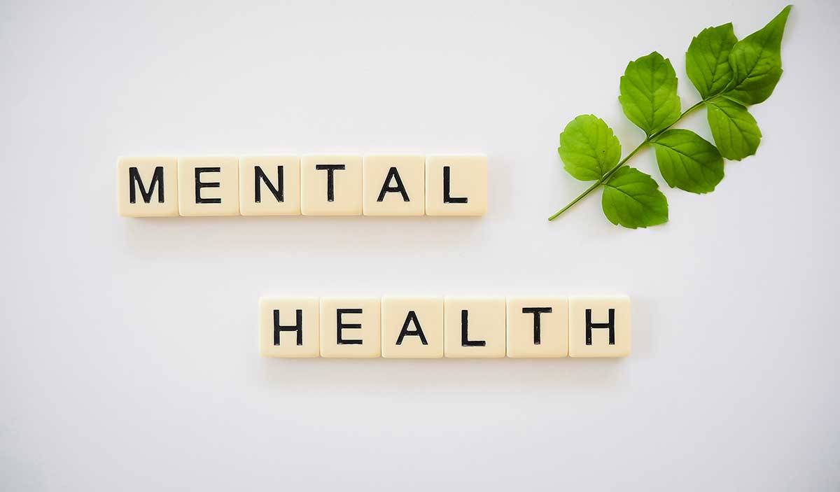 Scrabble pieces that spell out "mental health." 