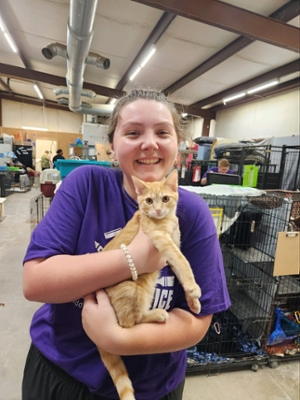Knight volunteering at the Houston humane society, holding a cat.