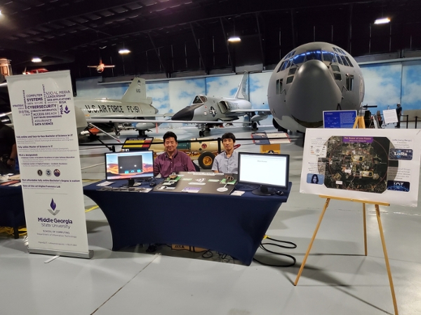 Faculty at their table at the Middle Georgia STEM City Expo held in the Museum of Aviation. 