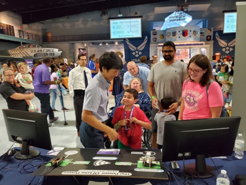 Faculty with guests at their table at the Middle Georgia STEM City Expo held in the Museum of Aviation. 