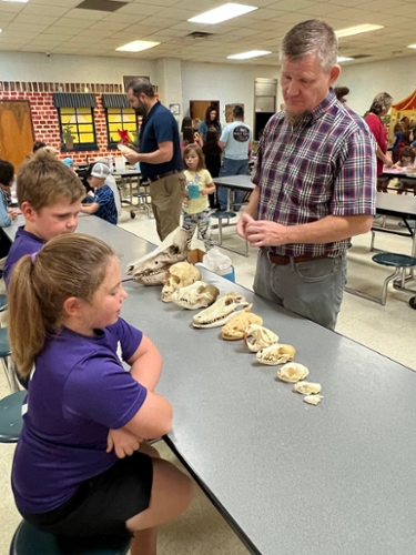 Faculty displaying animal skulls. 