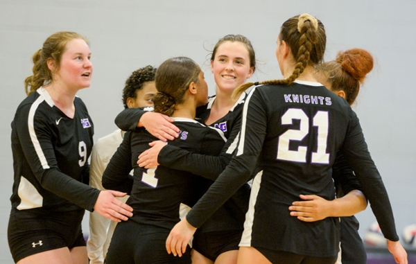 Knights volleyball team hugging after a game.