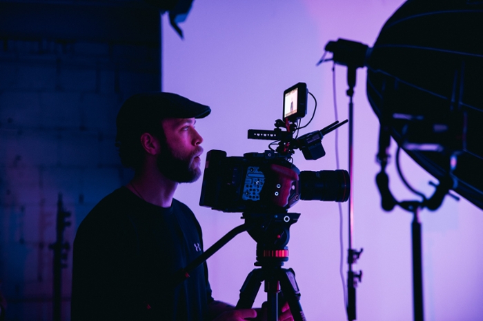 Videographer holding a camera on set. 