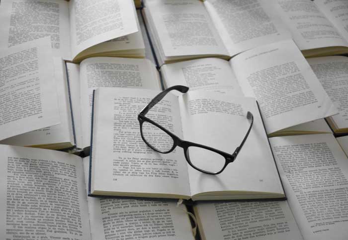 Glasses sitting on open books. 