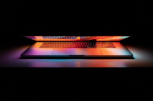 Laptop opening to reveal a colorful, abstract art background. 