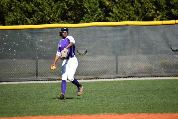 Knights softball player throwing a ball in the outfield. 