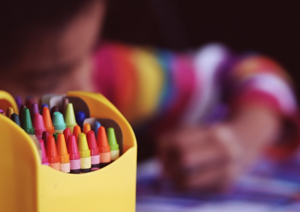 Kid coloring with crayons. 