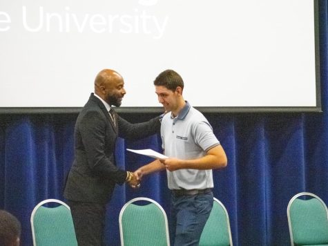 Carter Robinson, 20, shakes hands with Bibb Schools Superintendent Dan Sims at the Project SEARCH program graduation at Middle Georgia State University on May 18, 2023. Robinson is set to start working at ACE Hardware. Photo: Laura Corley, The Macon Newsroom