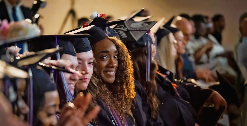 Black female student sitting in the crowd at MGA's spring 2024 commencement ceremony. 