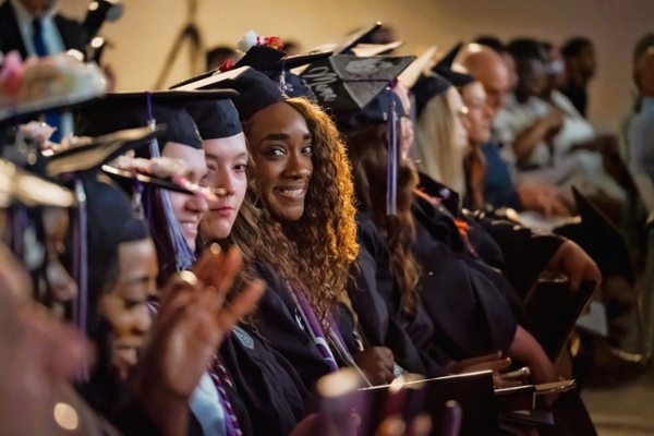 Black female student sitting in the crowd at MGA's spring 2024 commencement ceremony. 