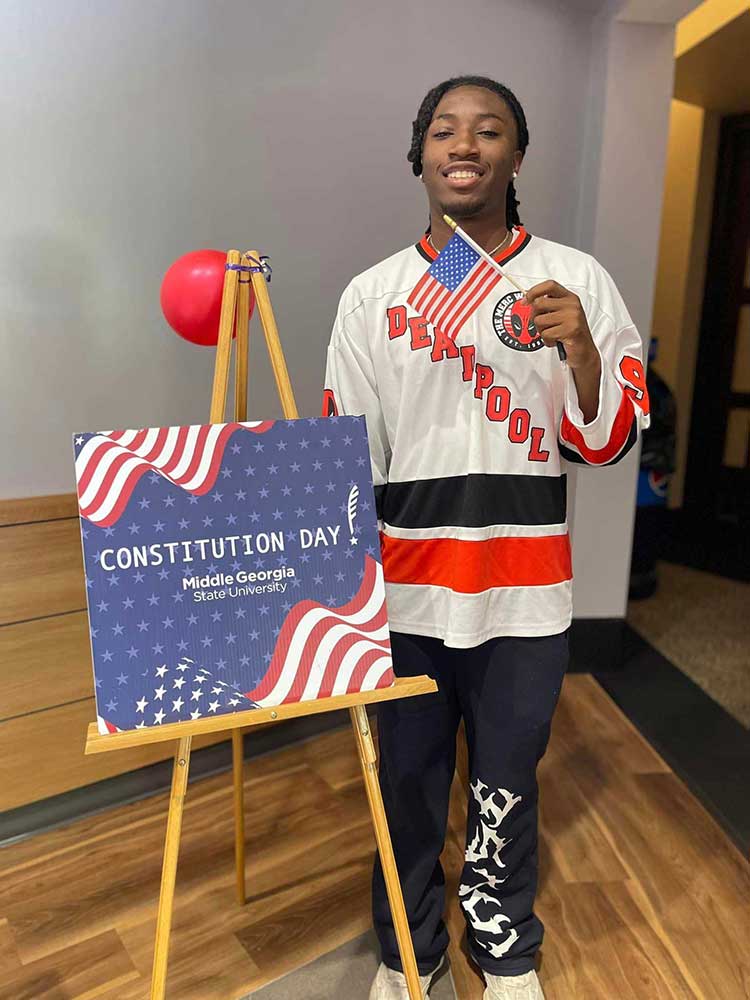 MGA student waves flag as he celebrates Constitution Day 2024.