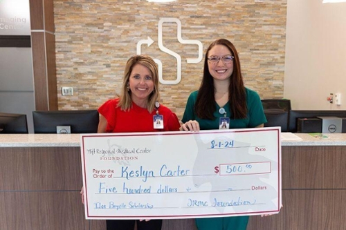 Mandy Brooks, left, executive director of the TRMC Foundation, presents the Ilse Boyette Book Scholarship to Keslyn Carter. A second scholarship recipient, Brittany Flanders, is not pictured. CREDIT: Tift Regional Medical Center Foundation