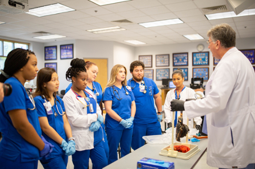 MGA RT students listen to a lecture in a lab setting.