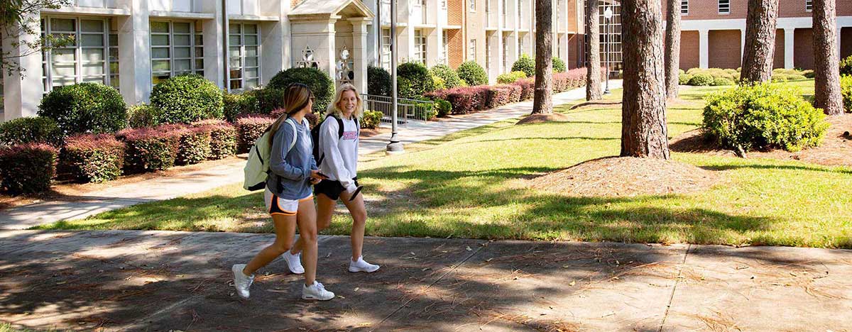 Two female students walking across MGA's Cochran Campus.