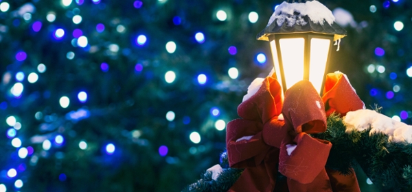 Close up photo of lantern lamp backlit with holiday lights. 