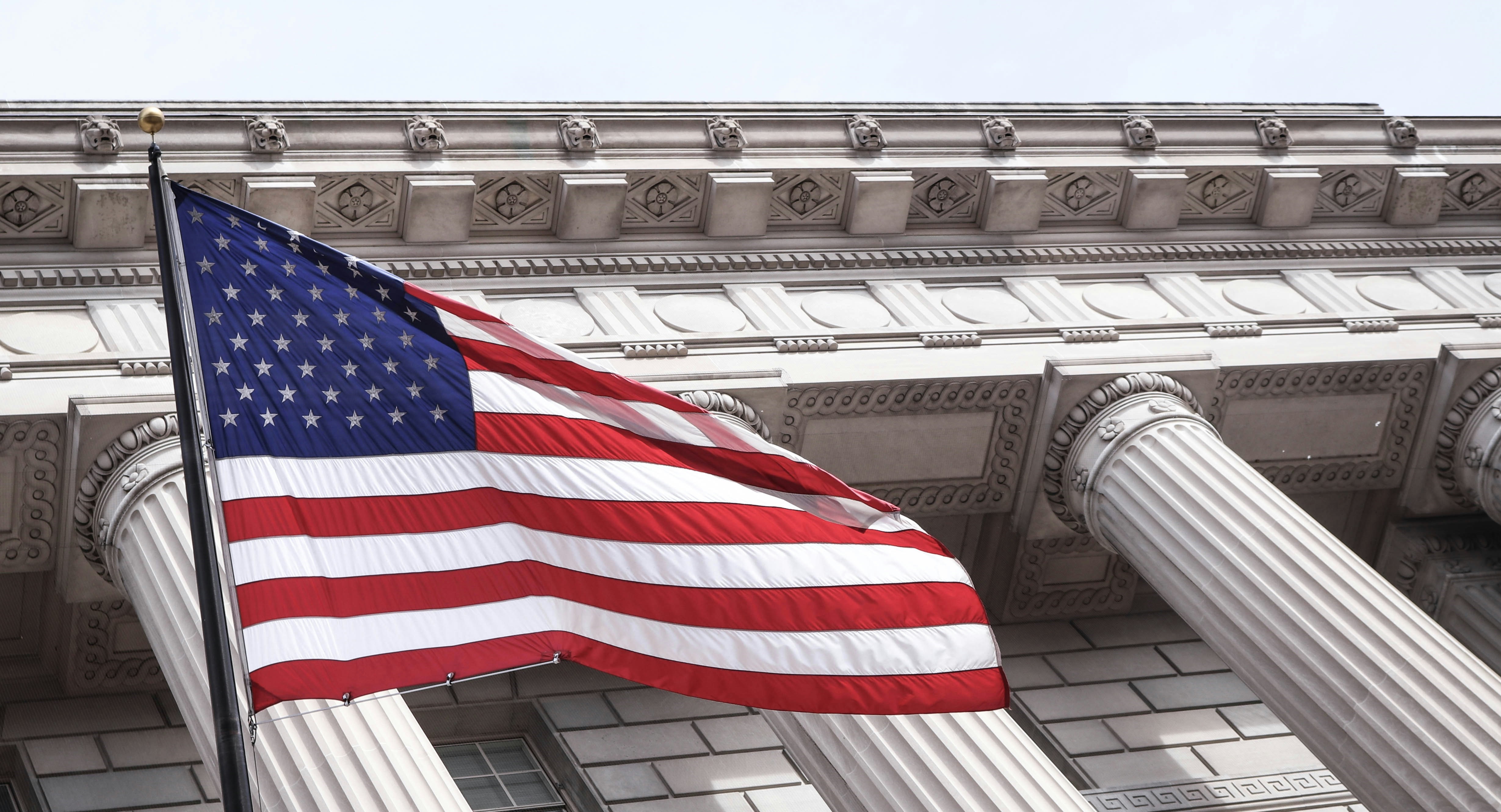 US flag flies next to municipal building. 