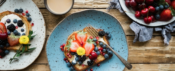 Flat lay of brunch foods on a table with silverware. 