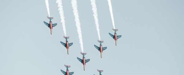 Red, white, and blue planes flying through the sky.